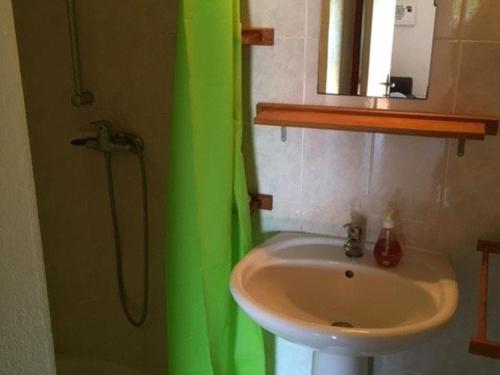 La salle de bains est pourvue d'un lavabo et d'un rideau de douche vert. dans l'établissement Villa T3 avec Piscine et Parking pour 6 pers à Port Barcarès - FR-1-81-256, au Barcarès