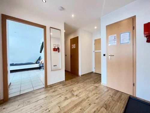 a room with a hallway with a door and wooden floors at 3-room Apartment Work & Stay in Baumberg