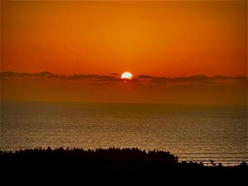 een zonsondergang boven de oceaan met de zon in de lucht bij Fanta Sea Vacation Stay - 2 Bhk with private Terrace Flat in Ganpatipule