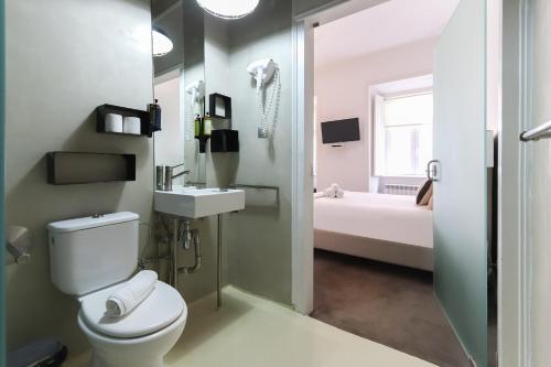 uma casa de banho com um WC branco e um lavatório. em Chiado Prime Suites by Homing em Lisboa