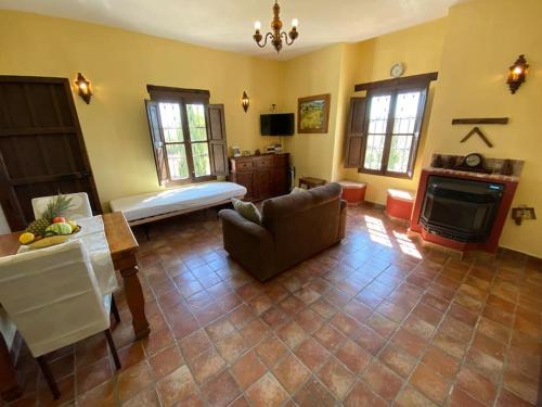 sala de estar con sofá y chimenea en Castle Tower ground floor apartment in rural holiday park 'Cezanne' en Tolox