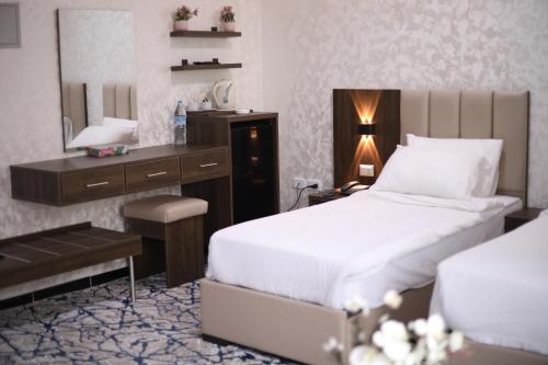 a bedroom with a bed and a desk and a mirror at The Castle Hotel in Amman