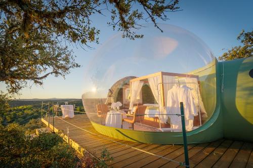 una gran cúpula de cristal situada en la parte superior de una terraza de madera. en Eco-Lodge en la Reserva Privada Campanarios de Azaba - Proyecto de Conservación, en Espeja