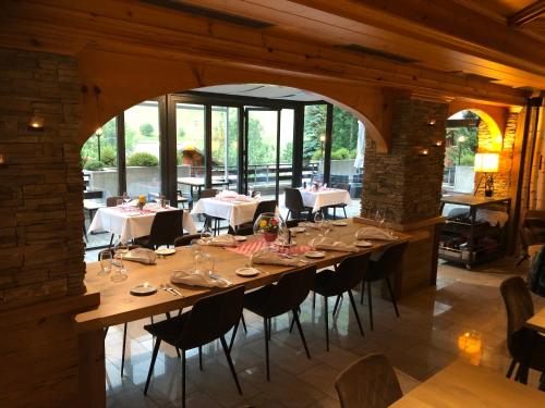 a long table in a restaurant with tables and chairs at Alfa Appartements Superior in Leukerbad