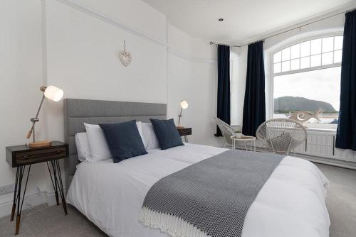 a bedroom with a large bed and a large window at Swn y Mor Deganwy in Deganwy