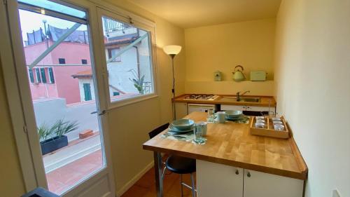 une petite cuisine avec une table et une fenêtre dans l'établissement I Tetti di Via Corradi, à Sanremo