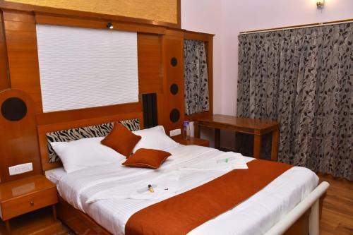 een slaapkamer met een groot bed met een houten hoofdeinde bij Glen Premium Villa By LexStays in Ooty