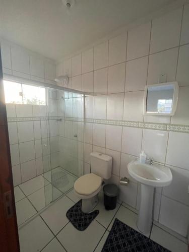 a bathroom with a toilet and a sink at Condomínio Serra da Saudade in Piçarras