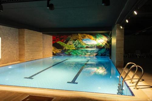 a large swimming pool with a painting on the wall at Arenya Home in Istanbul