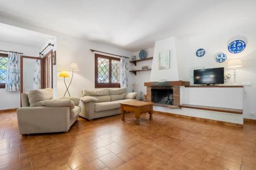 a living room with two couches and a fireplace at Hauzify I Casa l'Estany in L'Ametlla de Mar