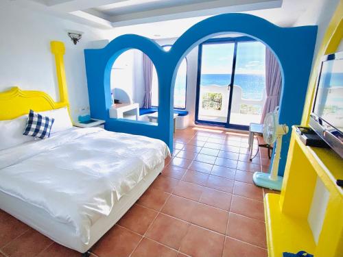 a bedroom with a bed and a tv and a window at Seyan Inn in Eluan