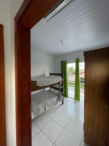 a bedroom with a bunk bed and a window at Condomínio Serra da Saudade in Piçarras