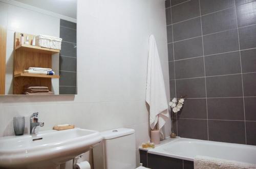 een badkamer met een wastafel, een toilet en een bad bij CAROLA l, "apartamento de lujo a 100m playa Catia" in Ribeira