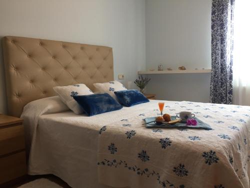 een slaapkamer met een bed met een dienblad met eten erop bij CAROLA l, "apartamento de lujo a 100m playa Catia" in Ribeira