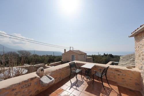 a balcony with two chairs and a table on a building at Lithos Stone Suites in Areopolis