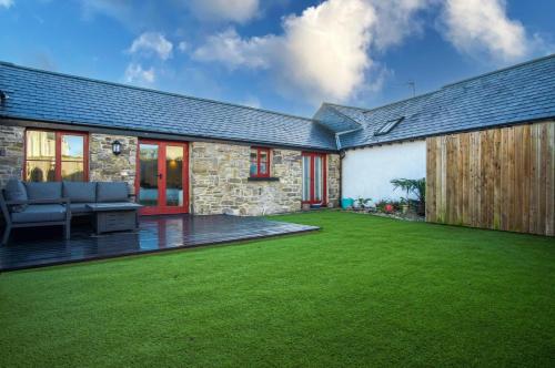 a garden with a lawn in front of a house at The Old Stables - 3 Bedroom Cottage - Angle in Angle
