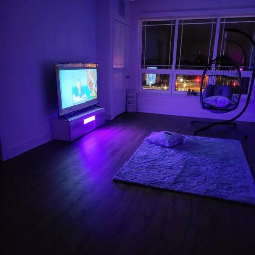 Habitación púrpura con TV y espejo. en Little cozy apartment, 