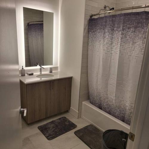y baño con lavabo y ducha con espejo. en Little cozy apartment, 
