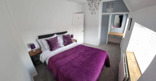 ウッドストックにあるYew Tree Houseのベッドルーム(紫色のベッド1台、紫色の毛布付)