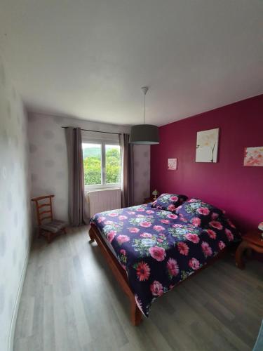 1 dormitorio con cama y pared púrpura en Maison chaleureuse, en Grézels