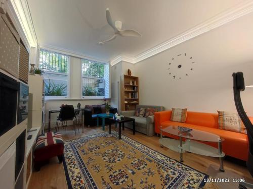 ein Wohnzimmer mit einem orangenen Sofa und einem Tisch in der Unterkunft Luxury 2-Bed Apartment in Central London in London