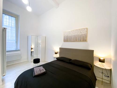 um quarto com uma cama grande e um cobertor preto em Corso Cavour - Raffinatezza nel cuore cittadino em Pavia