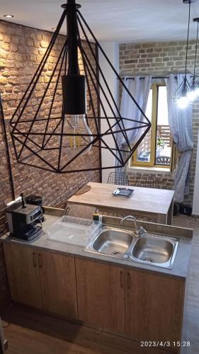 una cocina con 2 lavabos y luz eólica en HARI'S NEST CORFU, en Marathias