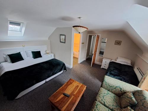 a bedroom with two beds and a couch at The Stables, Bron Y Graig, Corwen in Corwen