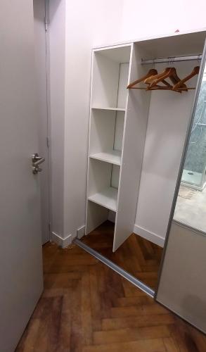 - un placard blanc avec une porte ouverte avec des chaussures dans l'établissement Histoire de Loire : GABRIELLE, à Saumur