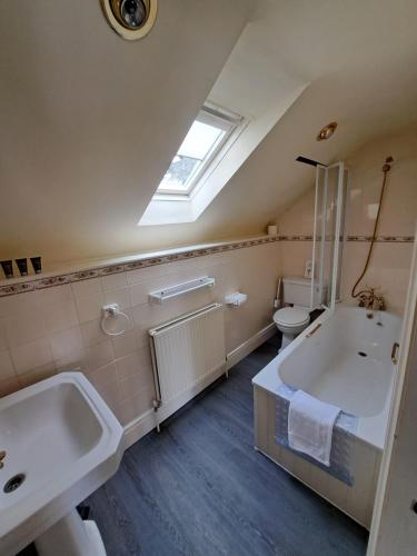 a bathroom with a sink and a tub and a toilet at The Stables, Bron Y Graig, Corwen in Corwen