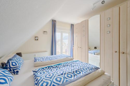 - une chambre avec un lit doté d'oreillers bleus et blancs dans l'établissement Ferienwohnung Hafennah Moba-Travel, à Lübeck