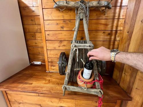 a person holding a wine bottle on a stand at Politkovskaia Apartment Tbilisi in Agaraki