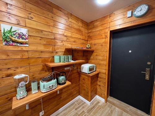 a room with wooden walls and a door and a clock at Politkovskaia Apartment Tbilisi in Agaraki