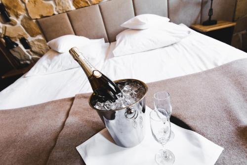 a bottle of champagne in a bucket on a table with glasses at Dwór w Zabużu in Zabuże