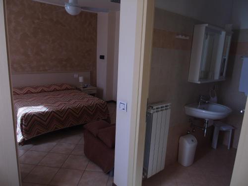 małą sypialnię z łóżkiem i umywalką w obiekcie Albergo Grifone 1891 w mieście Peschiera del Garda