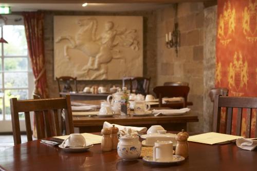 een eetkamer met een tafel met daarop theeserviezen bij The Cornmill in Kirkbymoorside