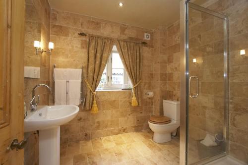 a bathroom with a toilet and a sink and a shower at The Cornmill in Kirkbymoorside