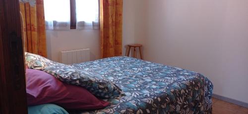 a bed with a blue comforter in a room at Au coeur de la Provence Verte in Le Cannet-des-Maures
