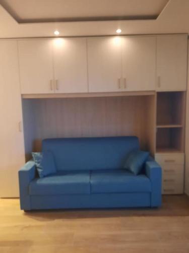 - un canapé bleu dans une pièce avec des armoires blanches dans l'établissement Bluemarine, studio vista Mare, à Menton