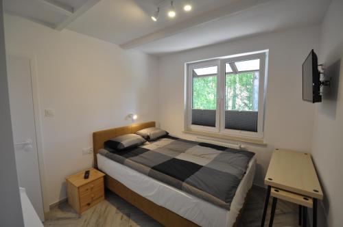 um quarto com uma cama grande e uma janela em Dziupla Dębki em Dębki