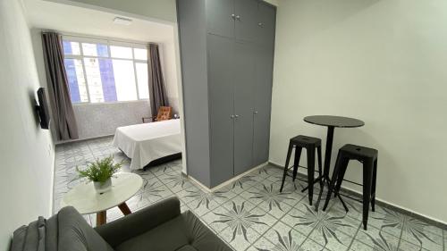 ein Wohnzimmer mit einem Sofa und einem Tisch in der Unterkunft Apartamento Frente à Praia Santos in Santos