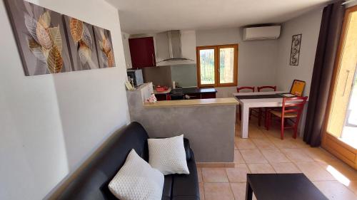 a living room and kitchen with a couch and a table at Villa Sénégas in La Roque-sur-Cèze