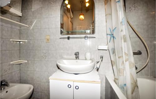 e bagno con lavandino, specchio e vasca. di 3 Bedroom Stunning Home In Cabestany a Cabestany