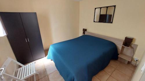 ラ・ロック・シュル・セーズにあるVilla Sénégasの青いシーツが置かれたベッド1台