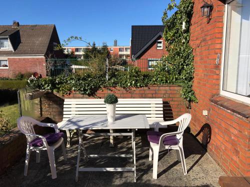 a table and two chairs and a white bench at Lotus 4 in Cuxhaven