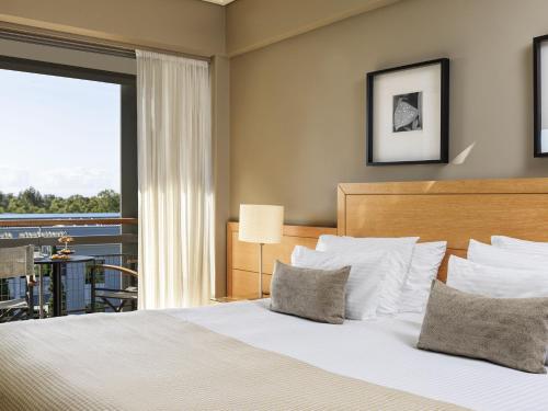 a bedroom with a bed and a large window at Sea View Cityscape Hotel in Athens