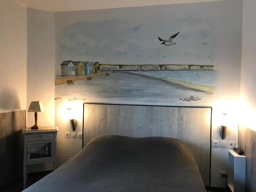 a bedroom with a large painting of a beach at Logis - Le Neptune Hôtel & Restaurant in Cayeux-sur-Mer