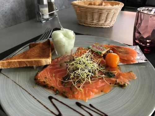 a plate of food with fish and bread and toast at Logis - Le Neptune Hôtel & Restaurant in Cayeux-sur-Mer