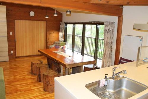 a kitchen with a sink and a table in a room at 『一軒丸々貸切』徒歩5分圏内カフェ 自然を満喫 Modern Ski Chalet +WiFi & 5min walk to cafes. in Nagano