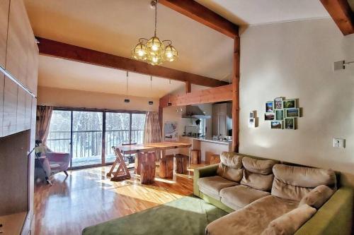 a living room with a couch and a table at 『一軒丸々貸切』徒歩5分圏内カフェ 自然を満喫 Modern Ski Chalet +WiFi & 5min walk to cafes. in Nagano